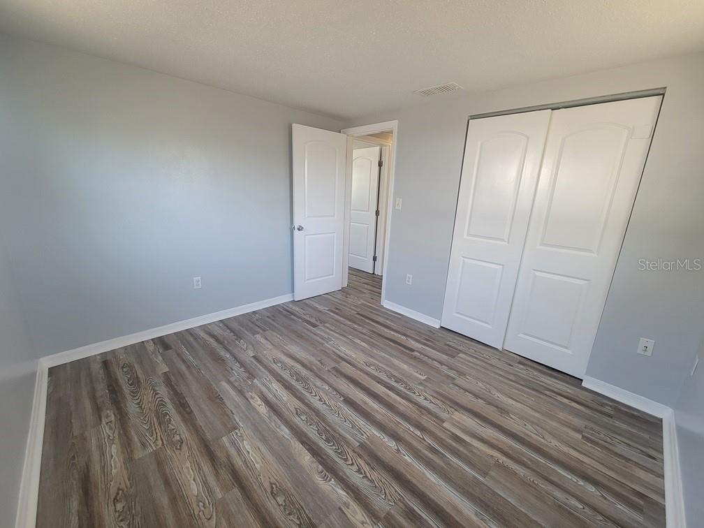 10225 Gardenia Lane Port Richey, FL 34668 - Photo 12 of 17 a view of empty room with wooden floor
