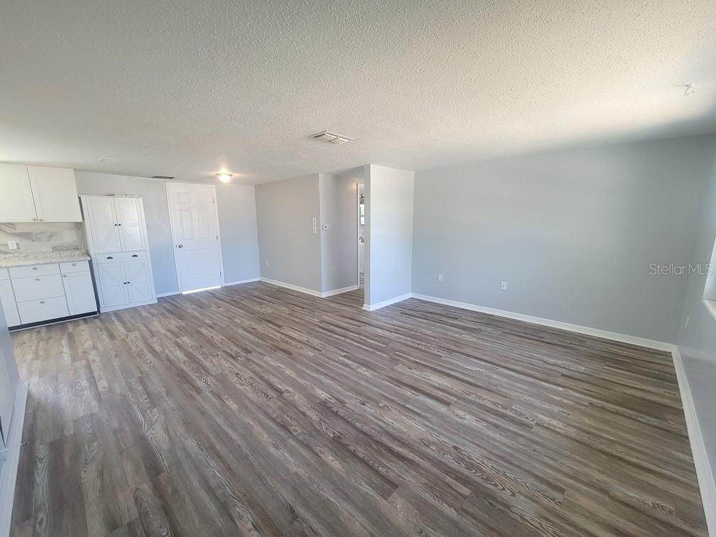 10225 Gardenia Lane Port Richey, FL 34668 - Photo 2 of 17 a view of an empty room with wooden floor