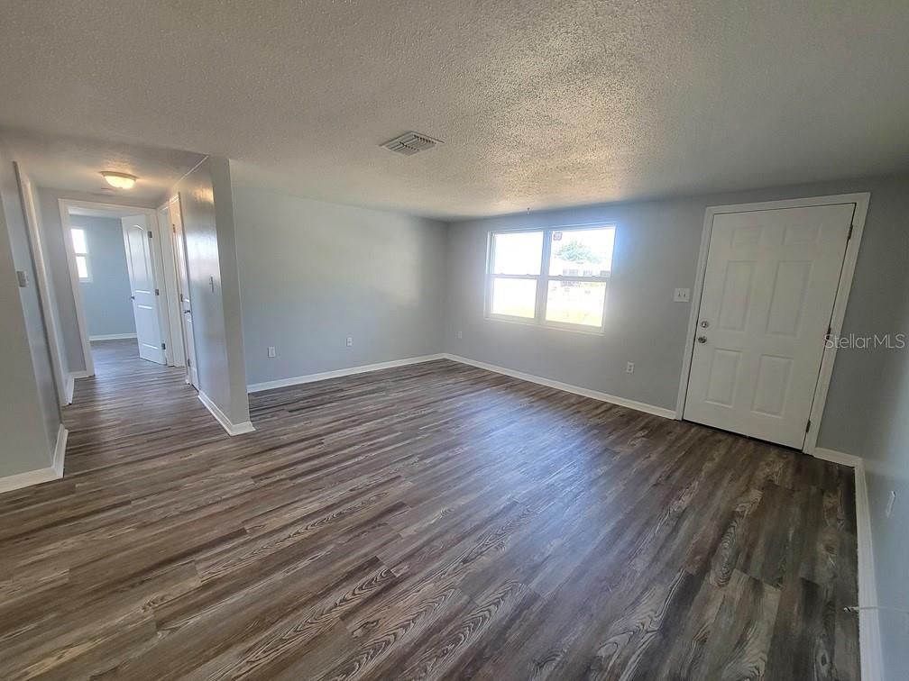 10225 Gardenia Lane Port Richey, FL 34668 - Photo 4 of 17 an empty room with wooden floor and windows