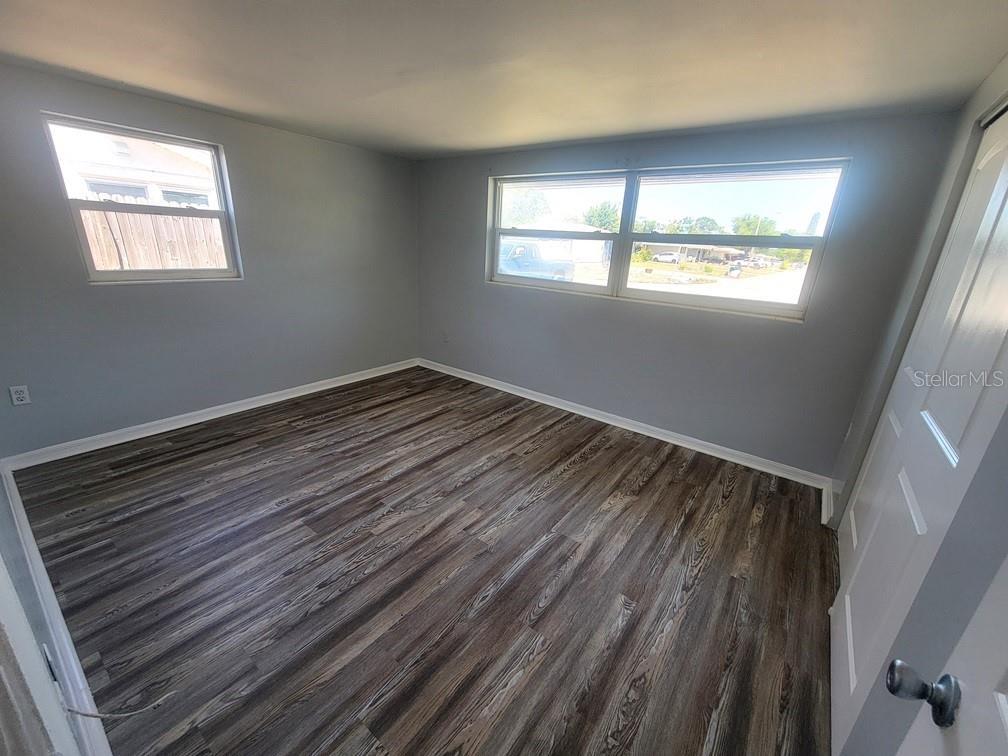 10225 Gardenia Lane Port Richey, FL 34668 - Photo 7 of 17 a view of an empty room with wooden floor and a window