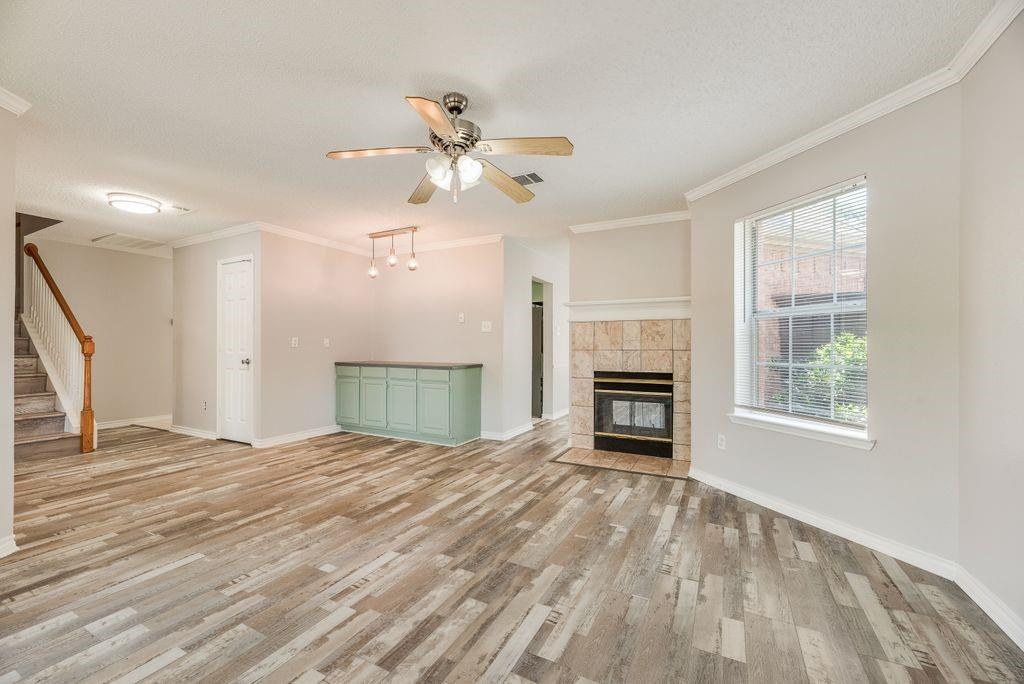 5610 Eagle Rock Road Arlington, TX 76017 - Photo 7 of 33 Spacious interior featuring wood-finish flooring, a tile-surround fireplace, and a built-in cabinetry unit