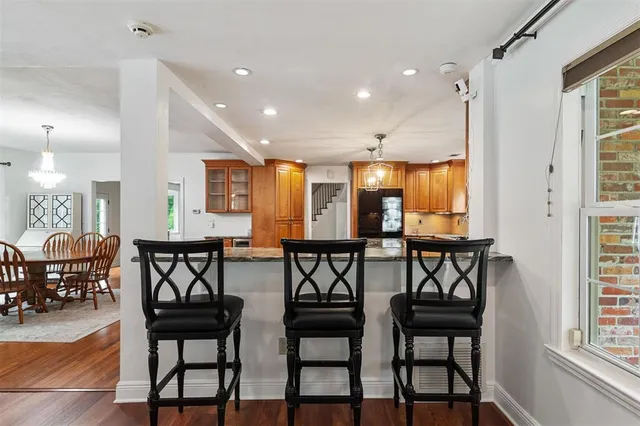 an empty room with wooden floor chandelier fan and windows
