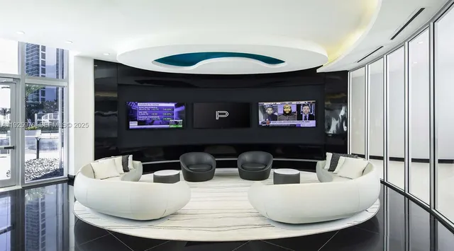 a living room with furniture a rug and a floor to ceiling window