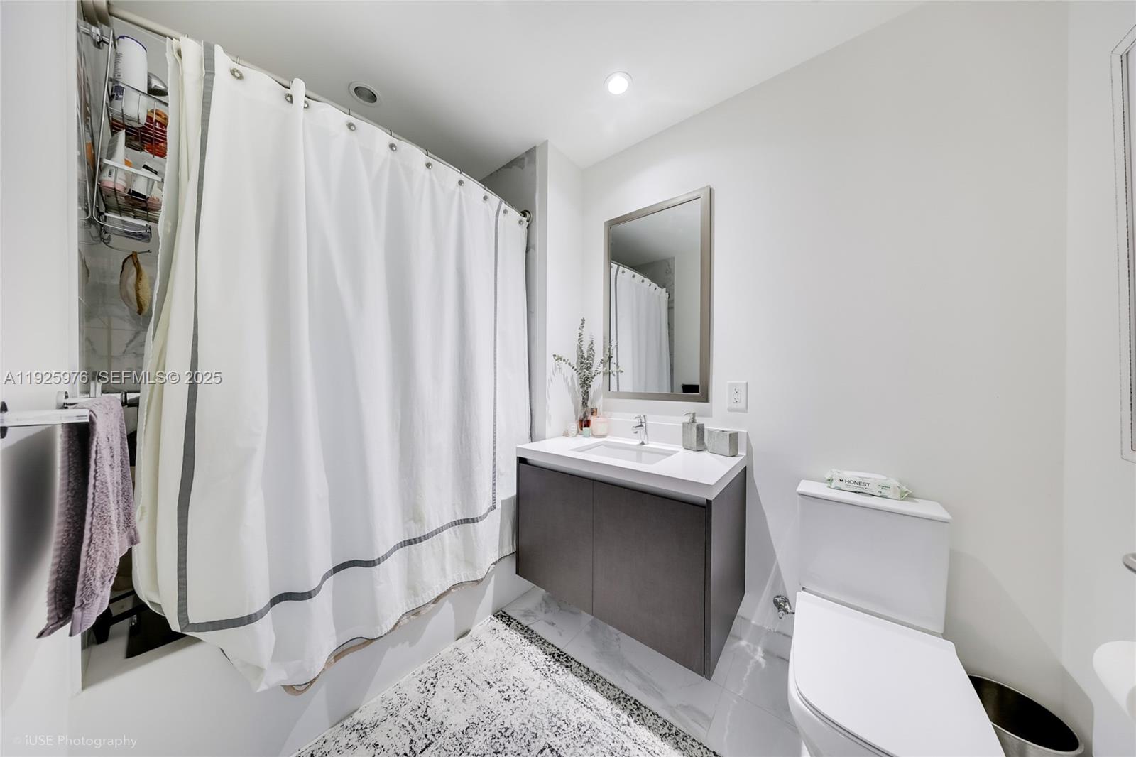 851 Northeast 1st Avenue, Unit 3810 Miami, FL 33132 - Photo 20 of 32 a bathroom with a sink a toilet and shower