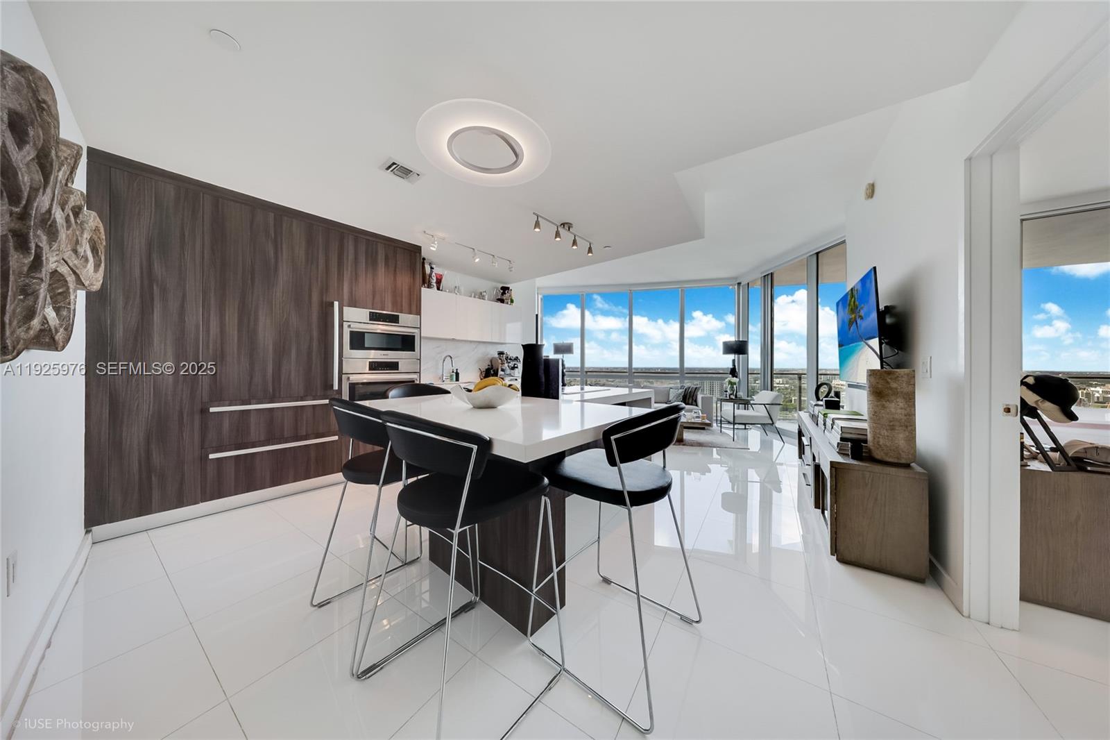 851 Northeast 1st Avenue, Unit 3810 Miami, FL 33132 - Photo 21 of 32 a kitchen with a dining table chairs and refrigerator