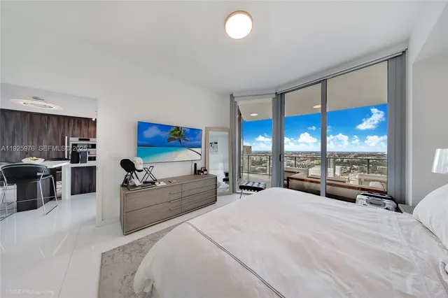 a large bedroom with bed and large window