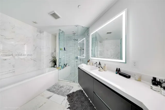 a bathroom with a double vanity sink mirror double and bathtub