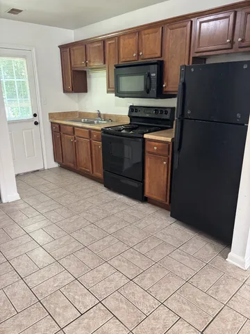 a kitchen with stainless steel appliances granite countertop a refrigerator stove and sink