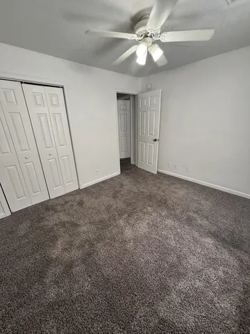 an empty room with fan and entrance