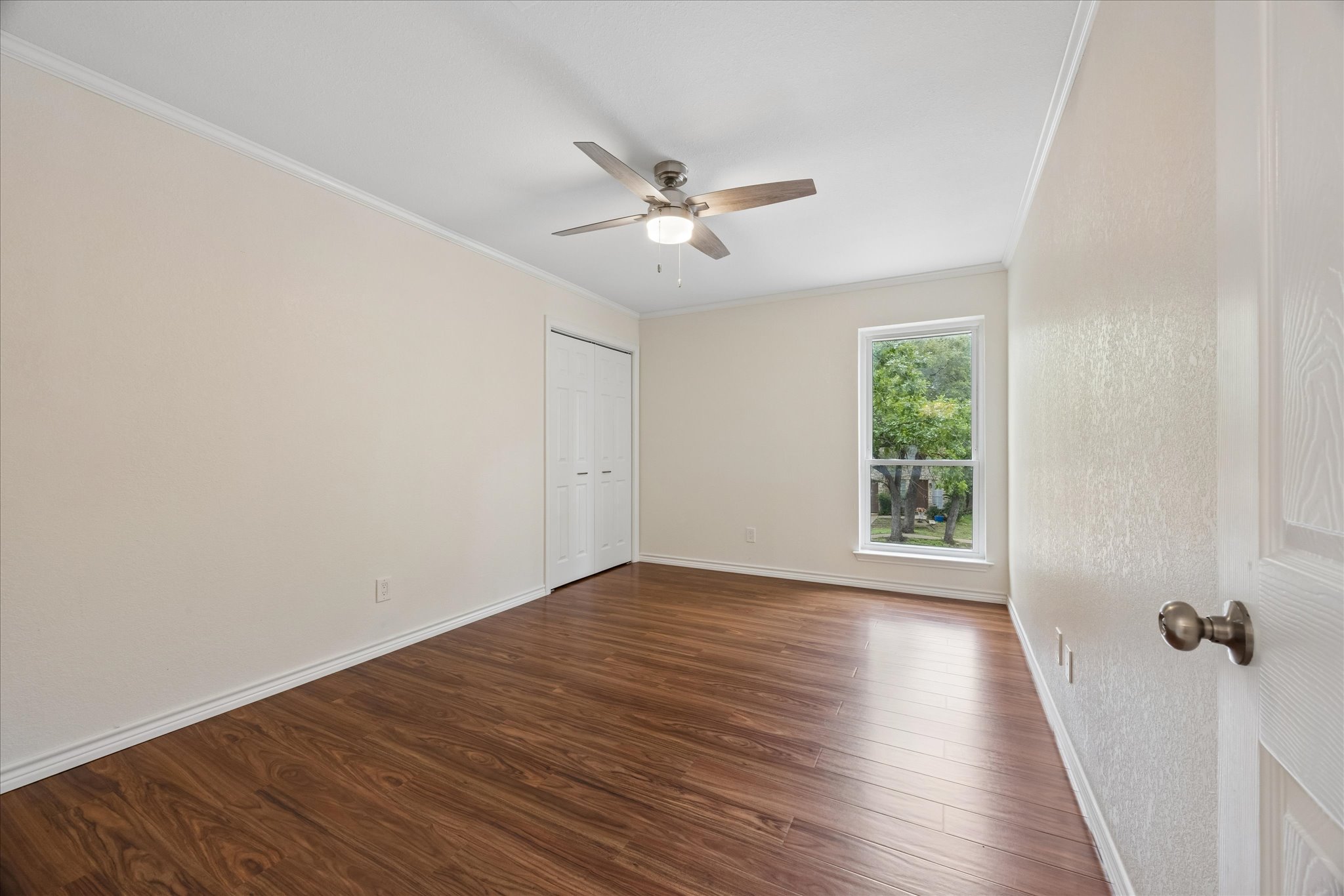 1306 Shady Grove Path Cedar Park, TX 78613 - Photo 27 of 40 an empty room with wooden floor fan and windows