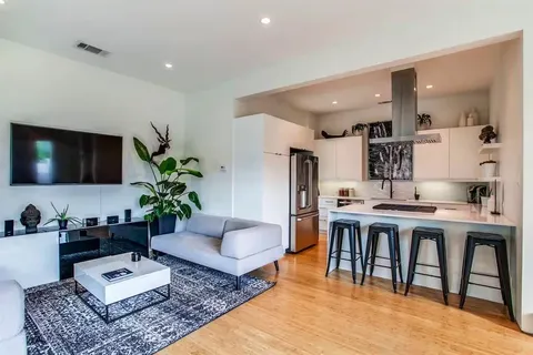 a living room with furniture kitchen view and a flat screen tv
