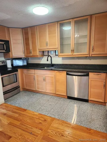 a kitchen with stainless steel appliances granite countertop a sink and a stove