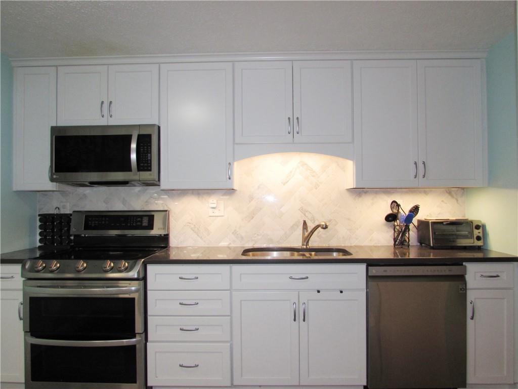 417 Rampart Boulevard New Kensington, PA 15068 - Photo 4 of 39 a kitchen with granite countertop white cabinets and stainless steel appliances