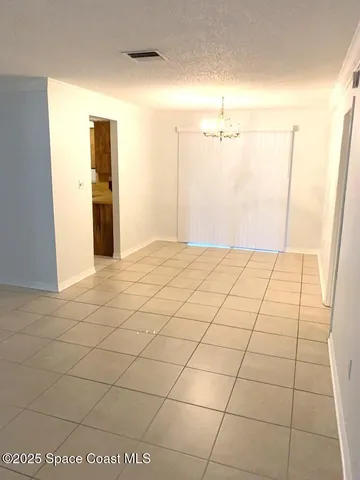 a view of a livingroom with an empty space and a window
