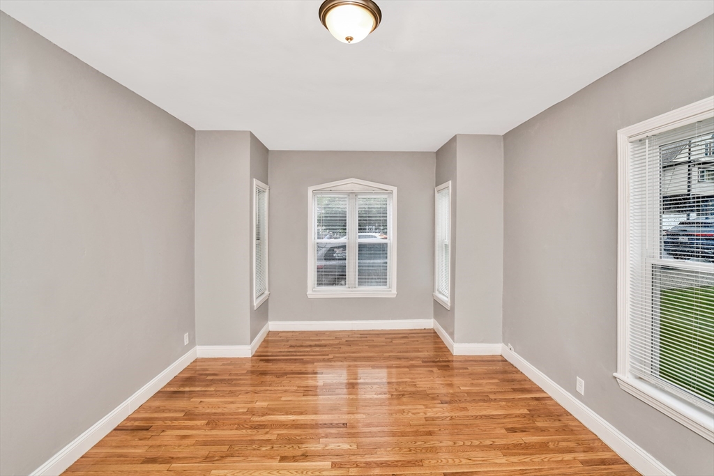 352 Norfolk Street, Unit 3 Boston, MA 02124 - Photo 12 of 12 a view of an empty room with wooden floor and a window