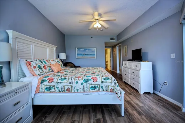 a bedroom with a bed and a flat tv screen on dresser