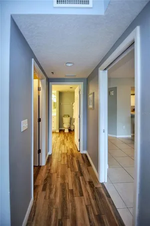 a view of a hallway with wooden floor and furniture