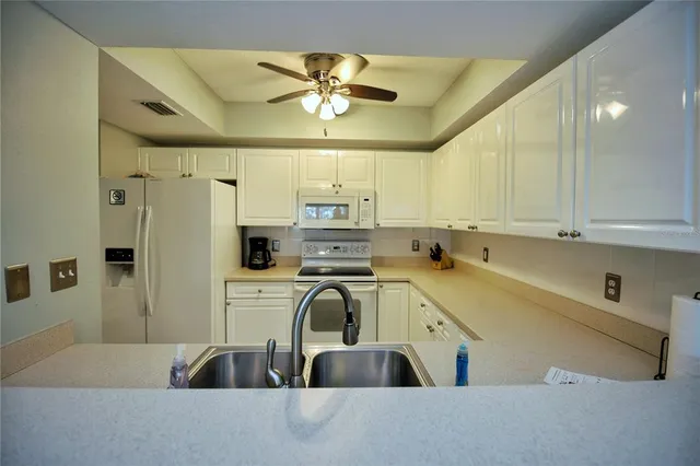 a view of a kitchen with a sink stainless steel appliances and cabinets