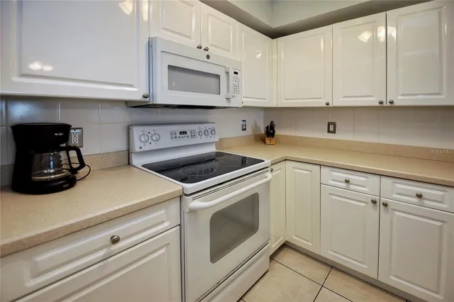 a kitchen with white cabinets and white appliances