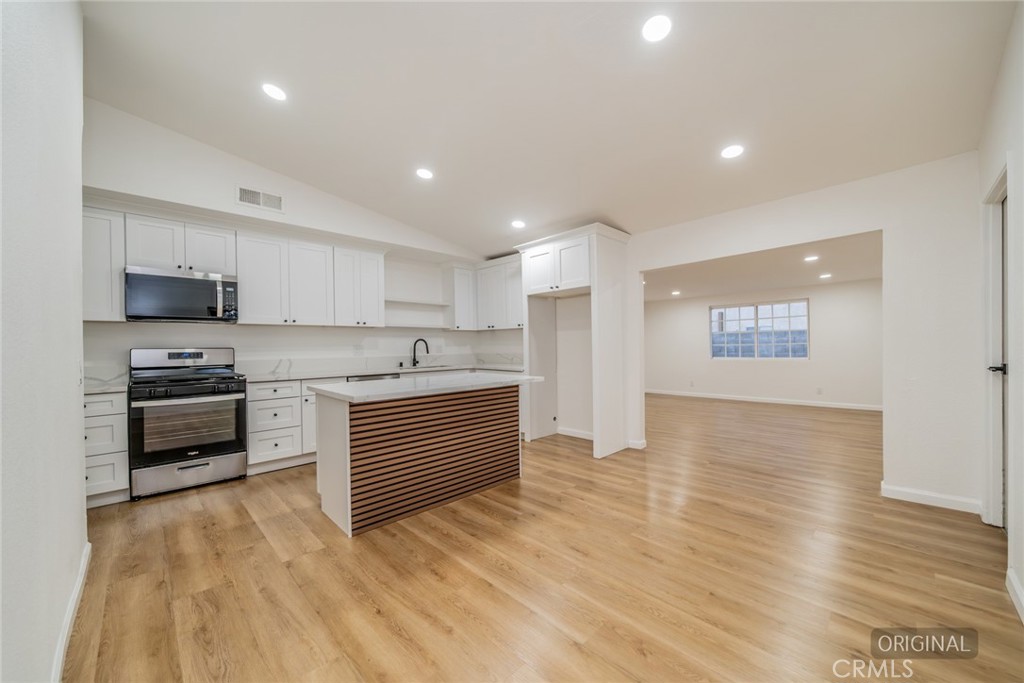 555 North Chestnut Avenue Rialto, CA 92376 - Photo 4 of 33 a large kitchen with cabinets and stainless steel appliances