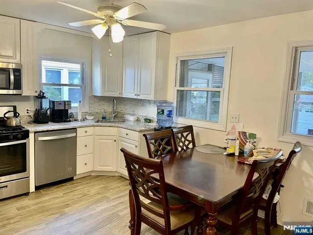 a kitchen with a dining table chairs sink and stove