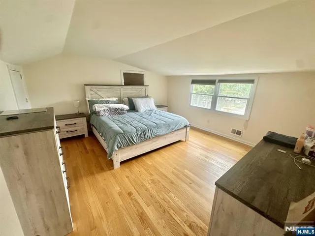 a bedroom with a bed and wooden floor