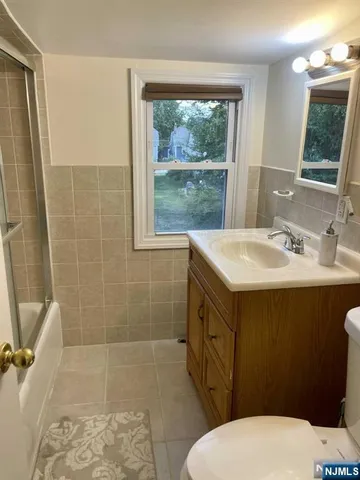 a bathroom with a sink a toilet a mirror and shower