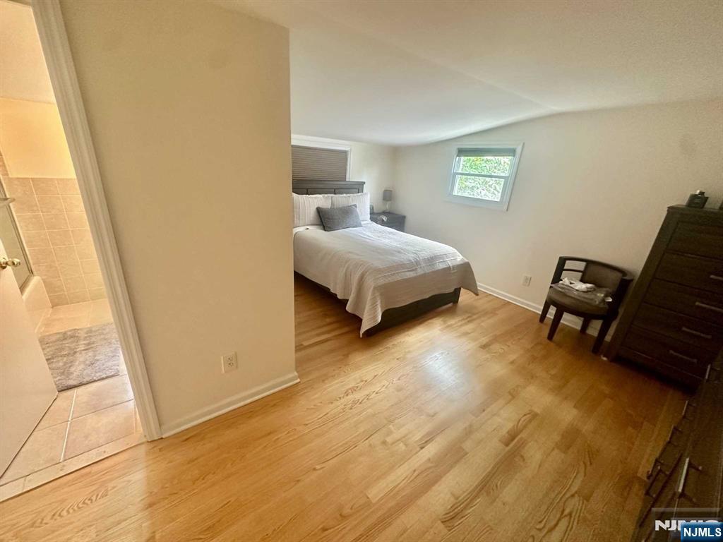 13 Jersey Avenue Mahwah, NJ 07430 - Photo 9 of 20 a spacious bedroom with a bed and wooden floor