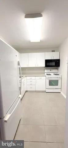 a view of washer and dryer with kitchen in the background
