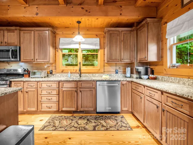 a kitchen with stainless steel appliances granite countertop a stove a sink and a wooden cabinets