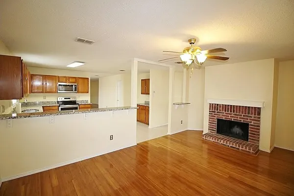 a open kitchen view with stainless steel appliances a stove top oven a refrigerator and a chandelier