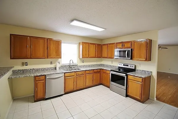 a kitchen with stainless steel appliances granite countertop a stove sink and cabinets