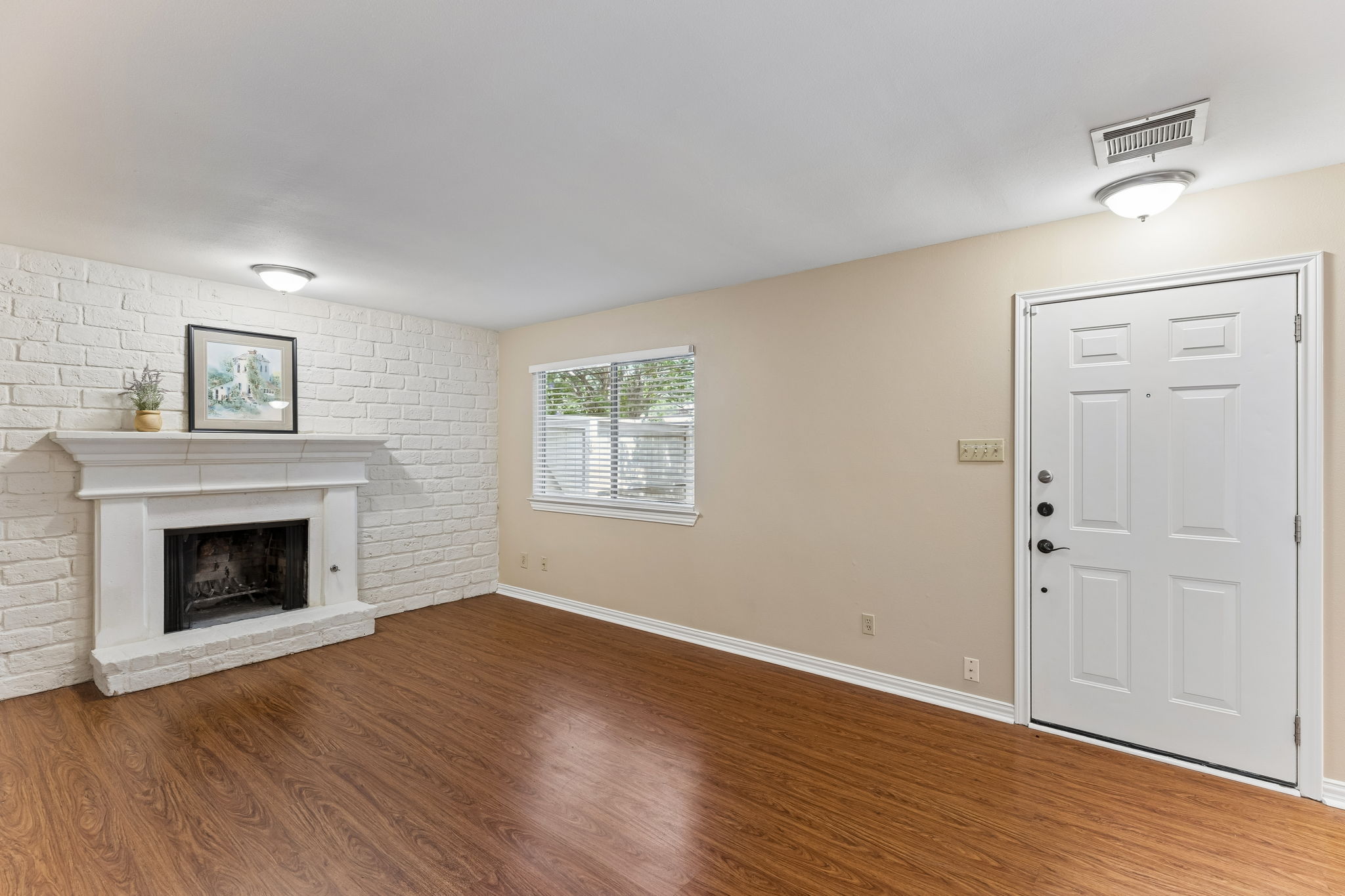 8340 Fathom Circle, Unit 103 Austin, TX 78750 - Photo 6 of 30 an empty room with wooden floor a fireplace and windows
