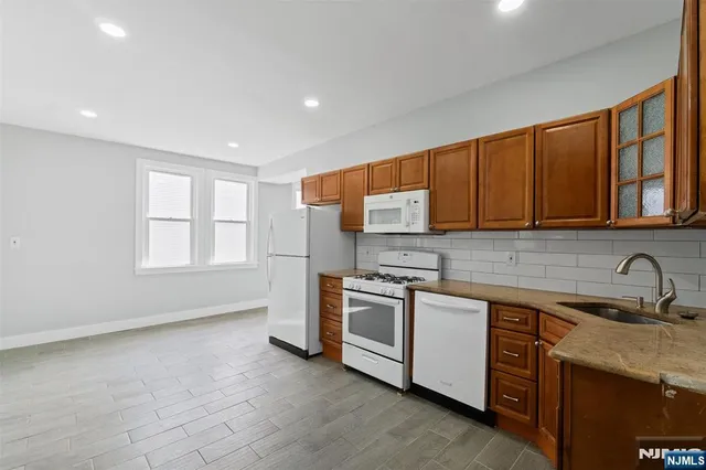 a kitchen with stainless steel appliances granite countertop a stove a sink and a microwave