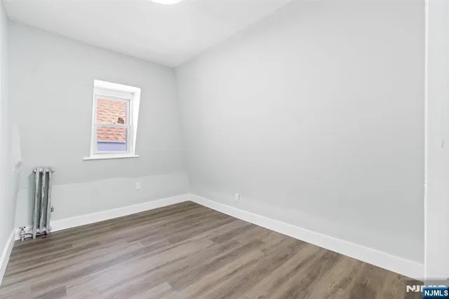 a view of a small space with wooden floor and a window