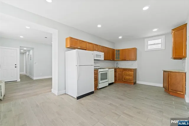 a kitchen with stainless steel appliances kitchen island granite countertop a refrigerator and a stove top oven