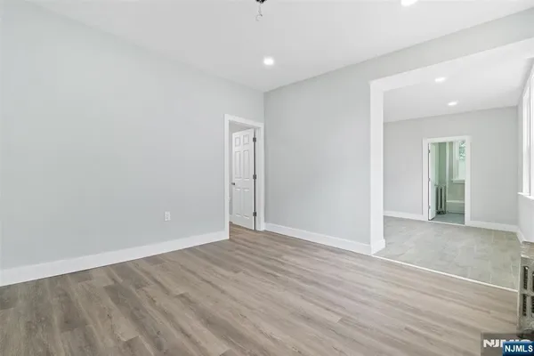 a view of an empty room with wooden floor
