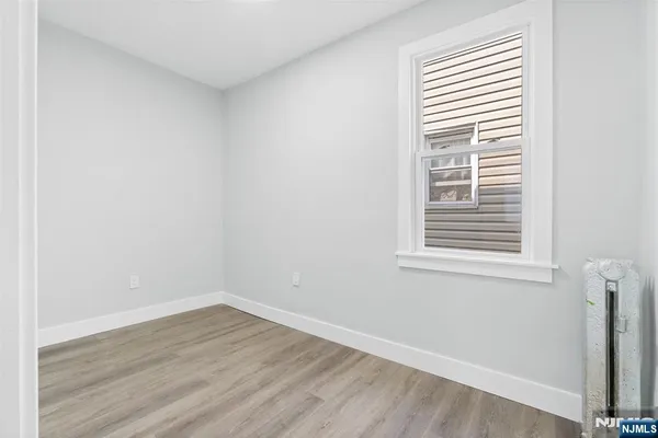 an empty room with wooden floor and a window