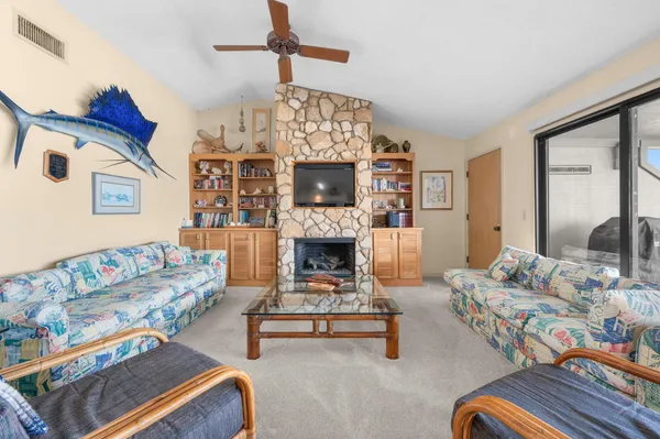 a living room with furniture a flat screen tv and a fireplace