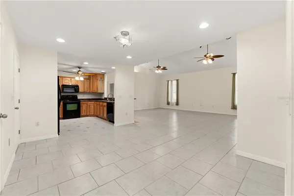 a living room with furniture kitchen view and a window