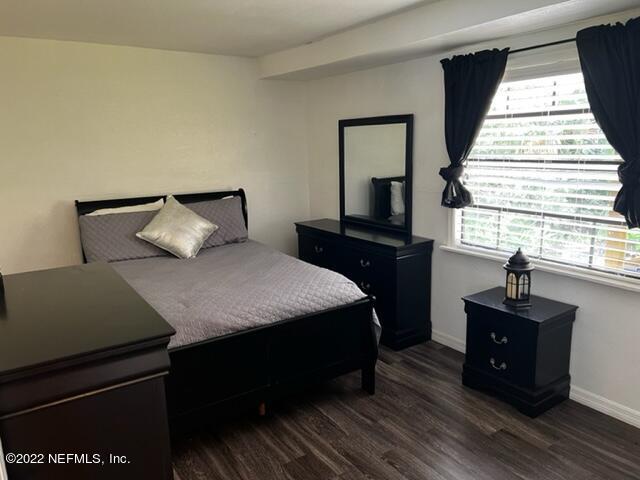 7222 Tropical Drive Weeki Wachee, FL 34607 - Photo 11 of 26 a bedroom with a bed and wooden floor