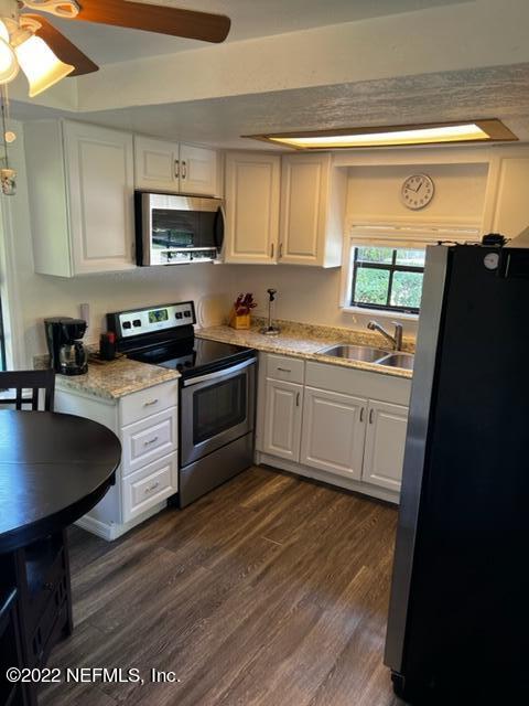 7222 Tropical Drive Weeki Wachee, FL 34607 - Photo 8 of 26 a kitchen with stainless steel appliances granite countertop a sink a stove a refrigerator a microwave a sink and cabinets