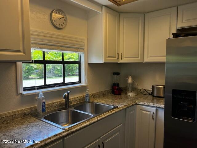 7222 Tropical Drive Weeki Wachee, FL 34607 - Photo 9 of 26 a kitchen with stainless steel appliances granite countertop a sink a stove and a refrigerator