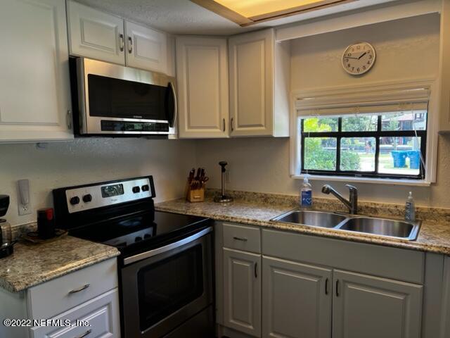 7222 Tropical Drive Weeki Wachee, FL 34607 - Photo 10 of 26 a kitchen with a stove and a microwave