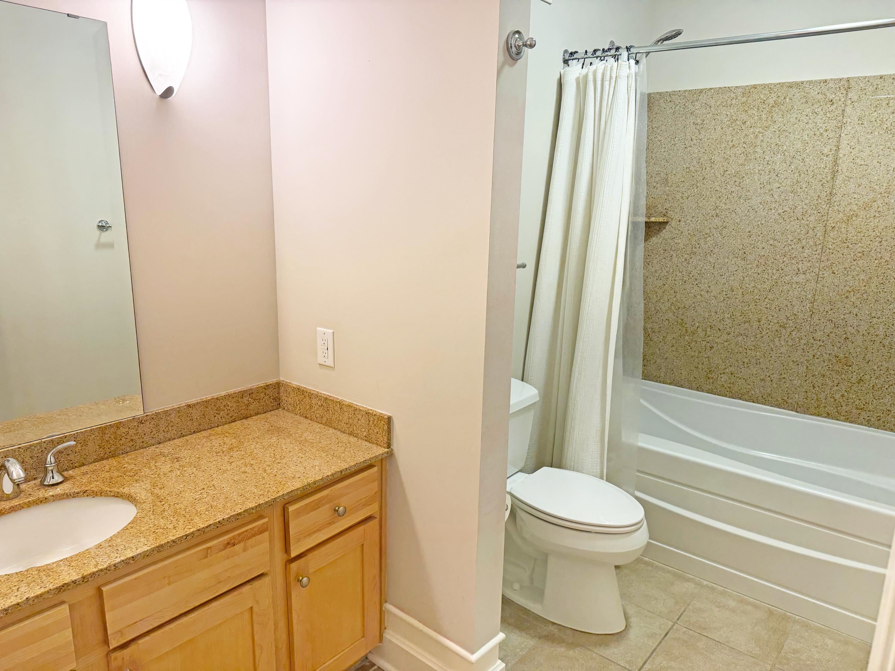 648 Riverside Drive, Unit 309 Memphis, TN 38103 - Photo 21 of 30 a bathroom with a granite countertop sink toilet and shower