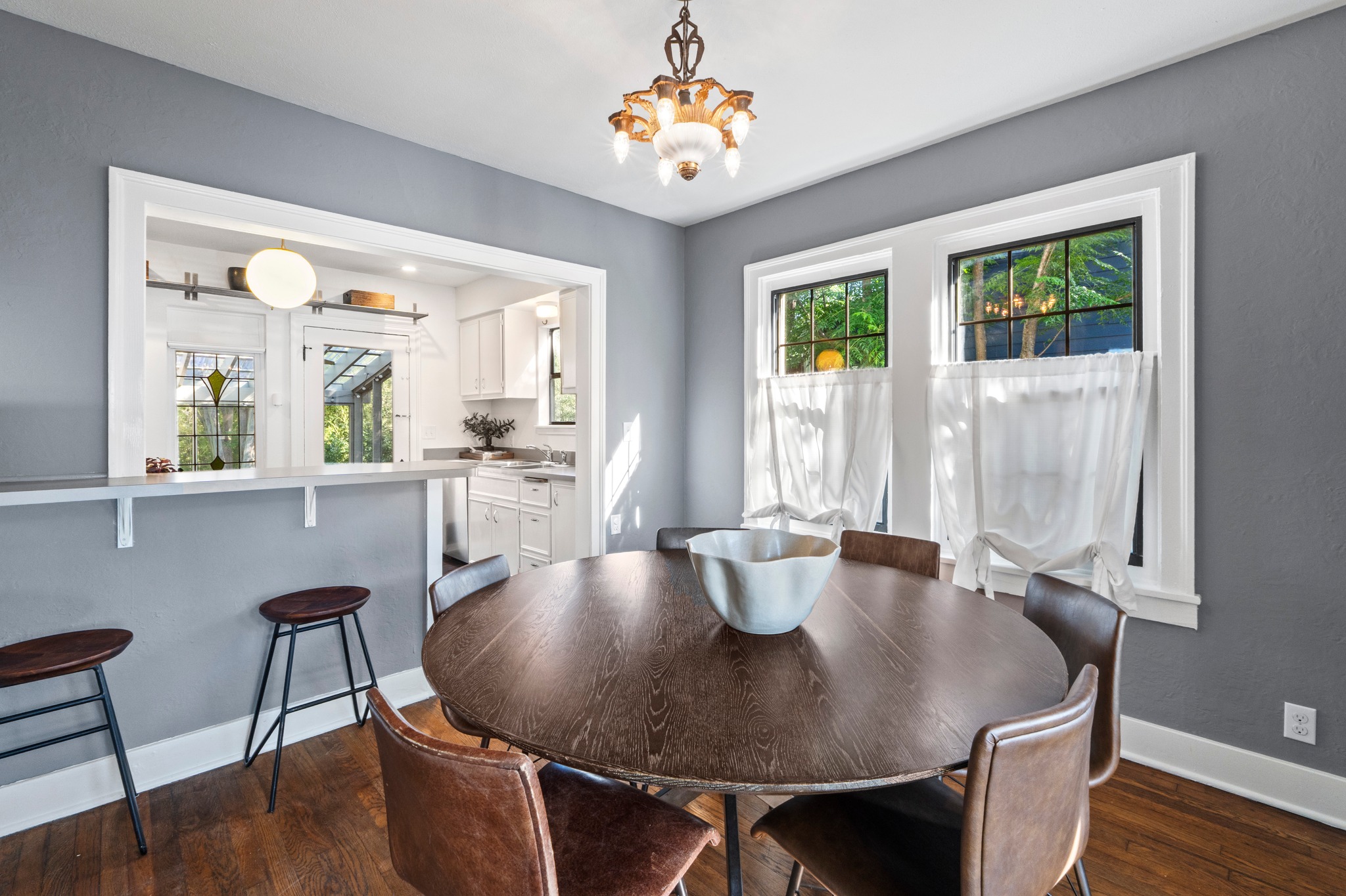 4802 Rowena Avenue Austin, TX 78751 - Photo 12 of 37 Dining area featuring original wood flooring and a decorative antique chandelier.