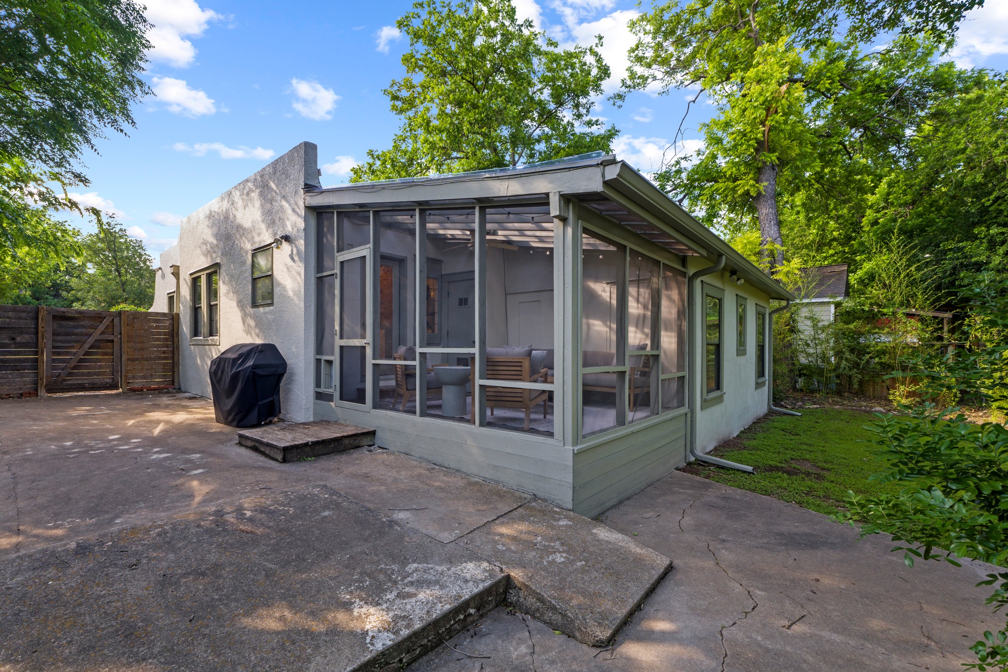 4802 Rowena Avenue Austin, TX 78751 - Photo 28 of 37 Exterior featuring a screened porch, stucco siding, and a concrete patio.