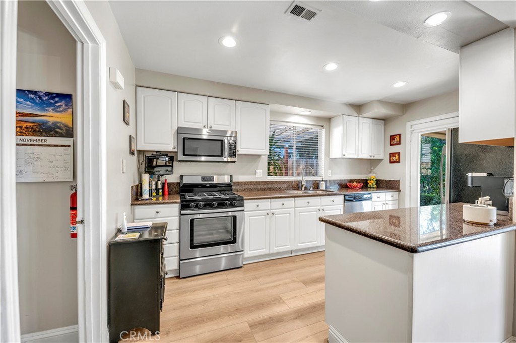 475 Termino Avenue Corona, CA 92879 - Photo 13 of 35 a kitchen with granite countertop a refrigerator stove top oven and sink