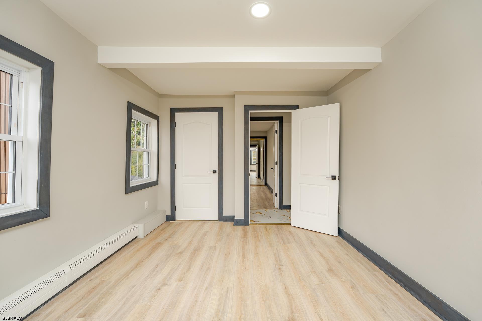 1203 West Mill Road Northfield, NJ 08225 - Photo 24 of 90 an empty room with wooden floor and windows