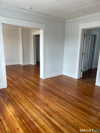 a view of empty room with wooden floor